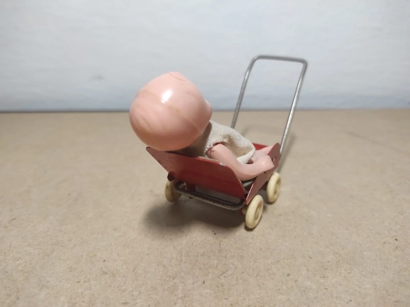 Starý plechový kočárek s panenkou