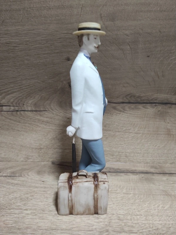 Porcelánová soška Royal Dux – pán s kufříkem a deštníkem